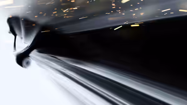a dark vehicle racing forward with sparks flying and blurred motion