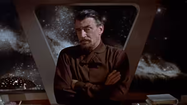 Dr. Morbius stands with arms crossed before a star-filled window