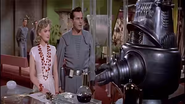 Altaira and Commander Adams stand beside a large machine in the laboratory