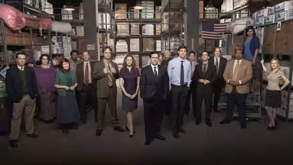 Michael Scott (Steve Carell) with colleagues posing in the warehouse