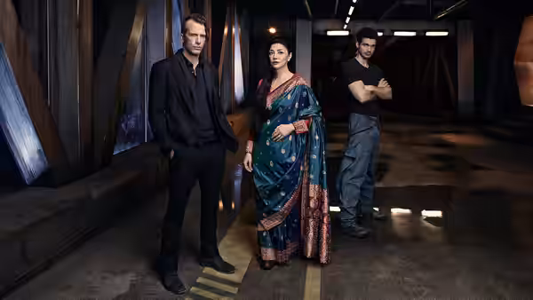 Chrisjen Avasarala stands between two men in a dimly lit corridor