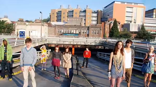 Group of young adults standing on a city bridge in daylight