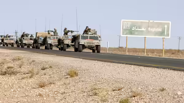 Convoy of military vehicles drives on a road toward Baghdad