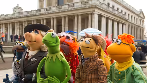 Kermit and the Muppets gather outside a grand columned building in London