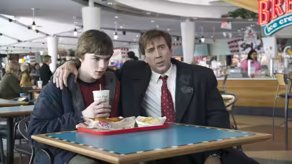 David Spritz (Nicolas Cage) sits with his son Mike (Nicholas Hoult) at a food court