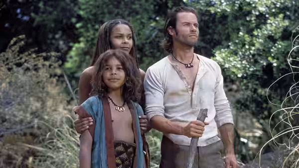 Alexander Hartdegen (Guy Pearce), Mara (Samantha Mumba) and Kalen (Omero Mumba) stand together in the forest