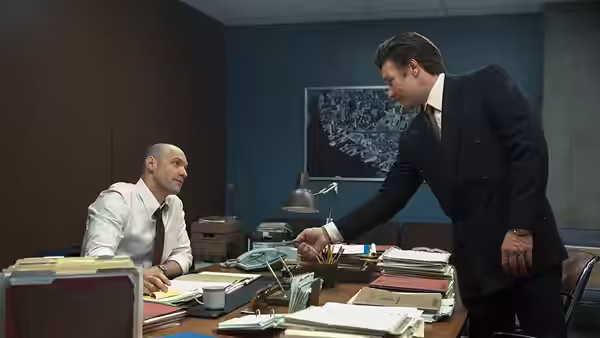John Connolly (Joel Edgerton) leans across an office desk toward a seated man