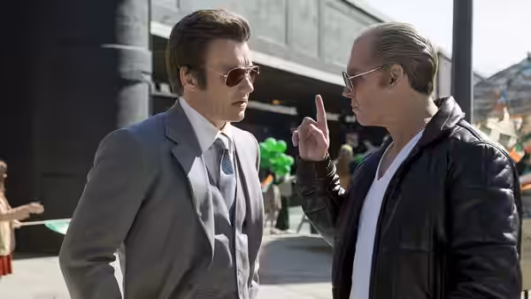 John Connolly (Joel Edgerton) listens as Whitey Bulger (Johnny Depp) speaks on a city sidewalk