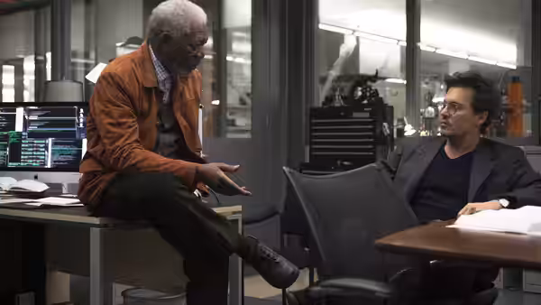Joseph Tagger (Morgan Freeman) gestures to Will Caster (Johnny Depp) in a laboratory