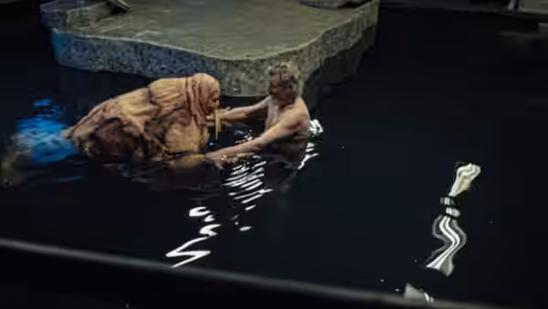 Howard Howe (Michael Parks) holds the walrus-suited Wallace Bryton in a dark pool