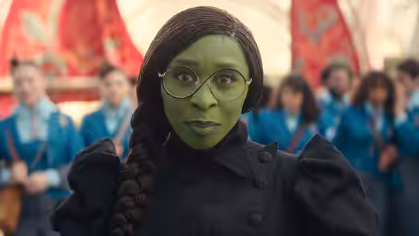 Elphaba (Cynthia Erivo) with glasses and braided hair looking ahead