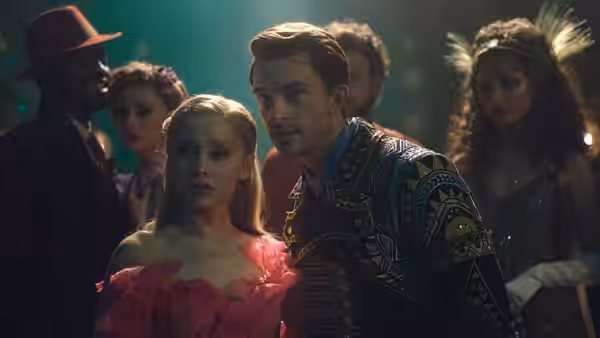 Galinda (Ariana Grande) and Fiyero (Jonathan Bailey) at a crowded party