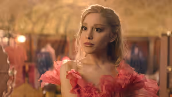 Galinda (Ariana Grande) in a pink ruffled dress glancing sideways