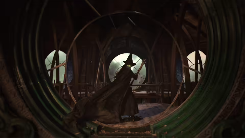 Elphaba (Cynthia Erivo) in a black cloak inside a green circular structure