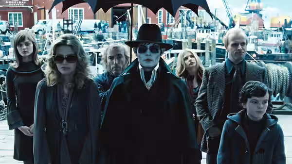 Barnabas Collins (Johnny Depp) and the Collins family gather beneath an umbrella at a harbor