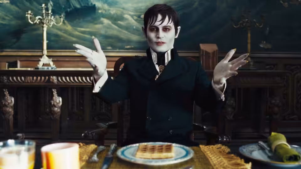 Barnabas Collins (Johnny Depp) gestures over a dining table in the Collins mansion