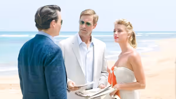 Sanderson (Aaron Eckhart) and Chenault (Amber Heard) stand with a man on a beach