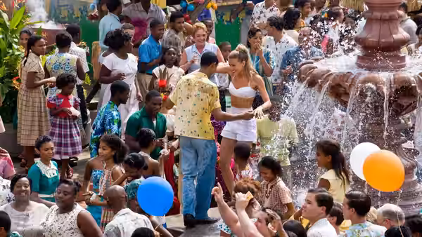 Chenault (Amber Heard) dances with a man beside a fountain as a crowd gathers