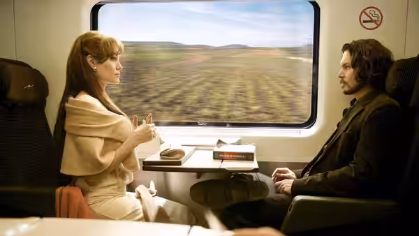 Elise Clifton-Ward (Angelina Jolie) and Frank Tupelo (Johnny Depp) sit opposite each other on a train