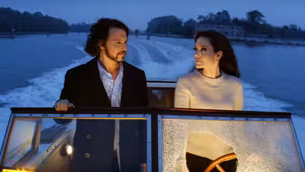 Frank Tupelo (Johnny Depp) and Elise Clifton-Ward (Angelina Jolie) stand aboard a boat at dusk