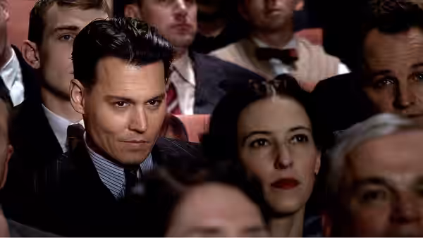 John Dillinger (Johnny Depp) and Billie Frechette (Marion Cotillard) sit among theatergoers