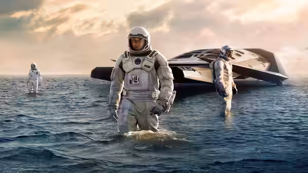 Cooper (Matthew McConaughey) wading in water beside a landed spacecraft at dusk