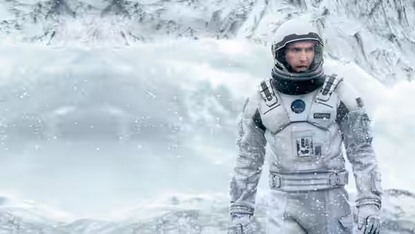 Cooper (Matthew McConaughey) in a spacesuit amid falling snow on an icy planet