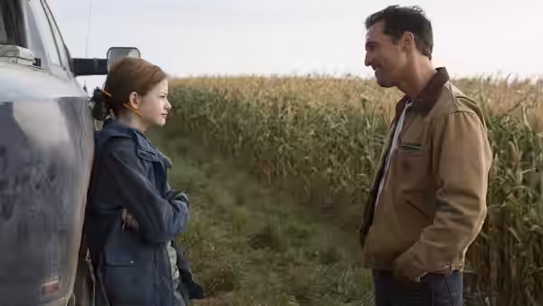 Murph (Mackenzie Foy) and Cooper (Matthew McConaughey) by a truck near a cornfield