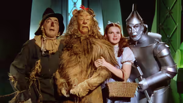 Dorothy (Judy Garland) comforting Cowardly Lion (Bert Lahr) with Scarecrow (Ray Bolger) and Tin Man (Jack Haley)