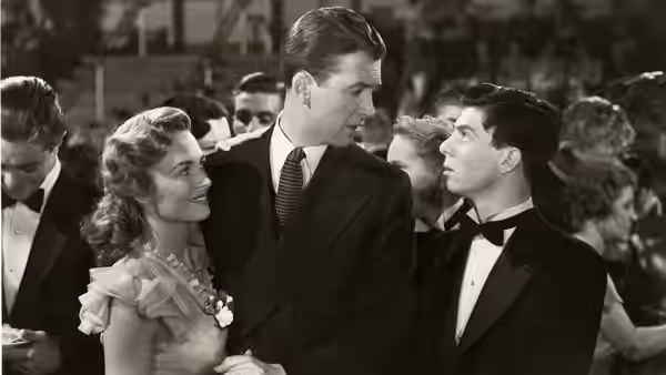 Mary Hatch (Donna Reed) smiles at George Bailey (James Stewart) at a formal gathering