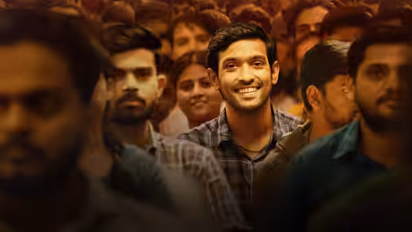 Manoj Kumar Sharma (Vikrant Massey) smiling in a large crowd