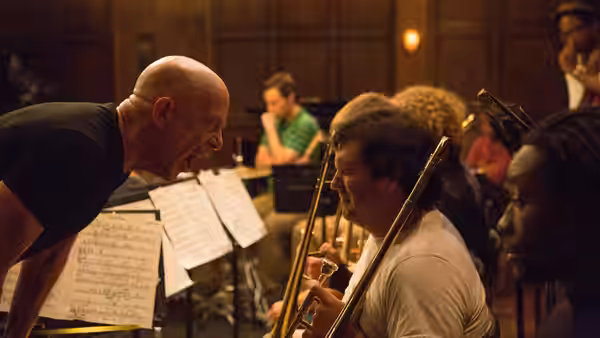Fletcher (J.K. Simmons) shouts at a trombonist during orchestra rehearsal