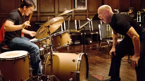 Andrew (Miles Teller) plays drums as Fletcher (J.K. Simmons) leans in shouting