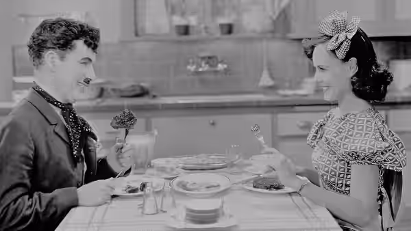 The Tramp (Charlie Chaplin) and A Gamin sharing a meal at home