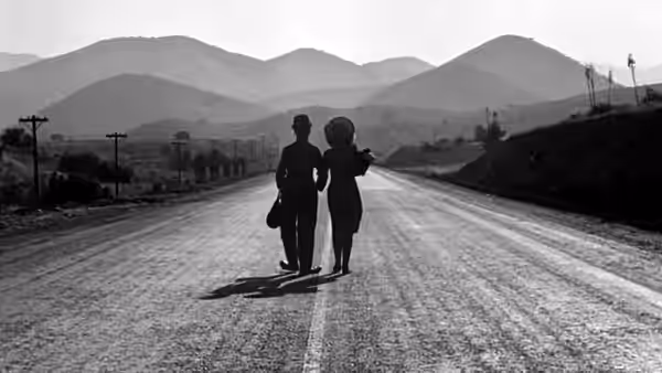 The Tramp (Charlie Chaplin) and A Gamin walking down a long road