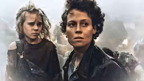 Ripley (Sigourney Weaver) and Newt (Carrie Henn) stand side by side in smoke