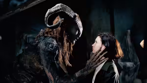 Fauno (Doug Jones) touching Ofelia's (Ivana Baquero) face in a dark chamber