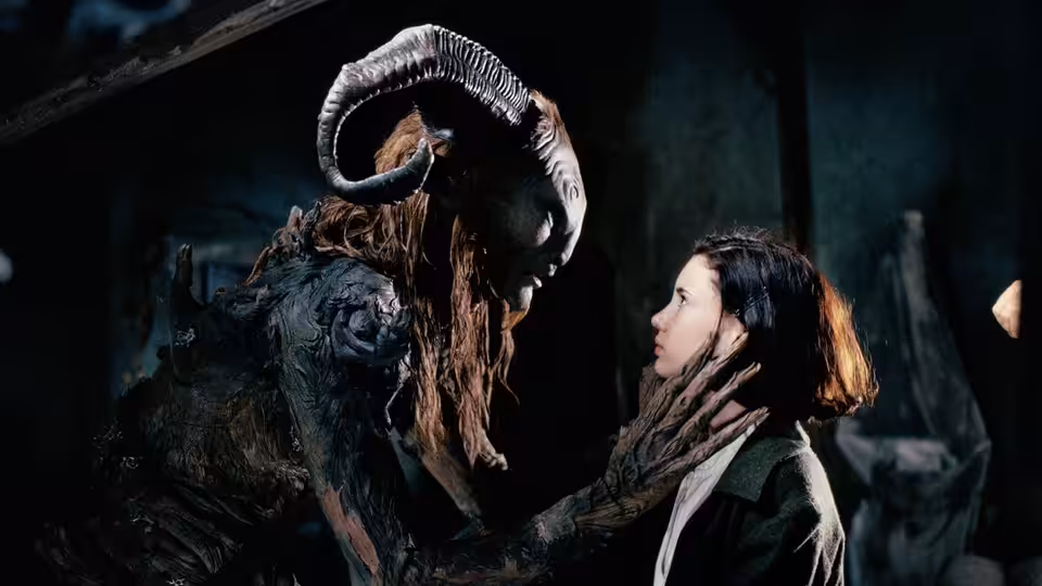 Fauno (Doug Jones) touching Ofelia's (Ivana Baquero) face in a dark chamber