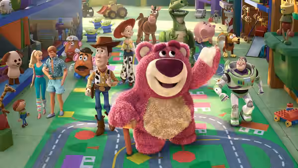 Lotso waving in a daycare playroom surrounded by many toys