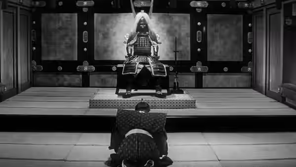 An armored lord sits on a dais facing a kneeling samurai