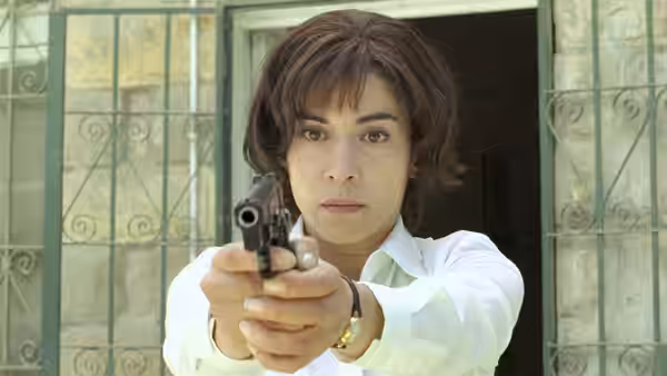 Nawal (Lubna Azabal) aims a pistol forward with both hands
