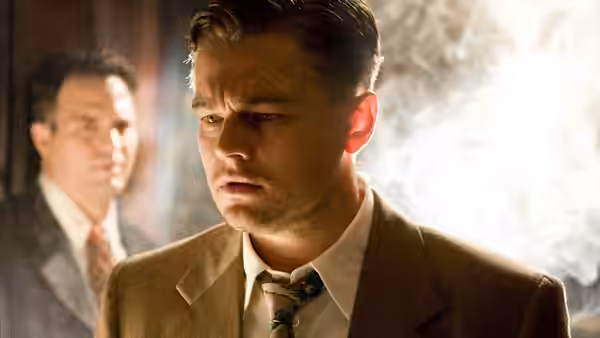 Teddy Daniels (Leonardo DiCaprio) with head bandage gazes downward in dim light