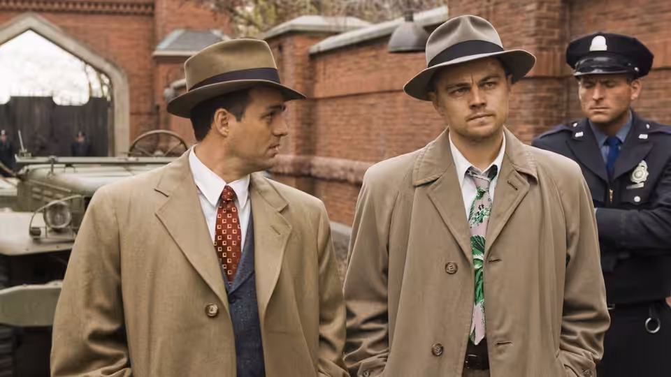 Teddy Daniels (Leonardo DiCaprio) and Chuck Aule (Mark Ruffalo) confer near a policeman