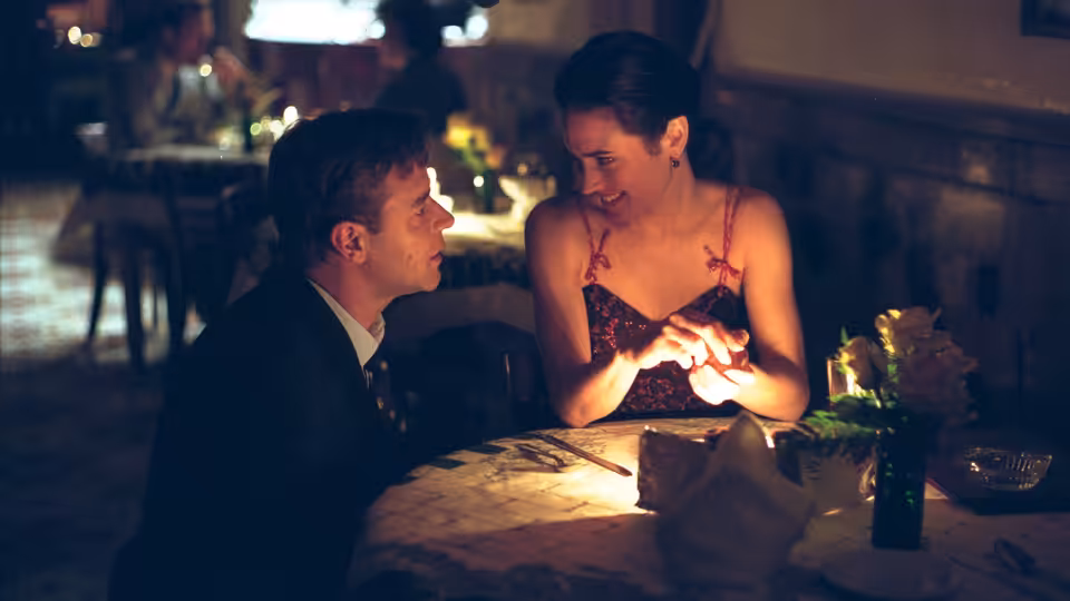 John Nash (Russell Crowe) and Alicia Nash (Jennifer Connelly) holding hands at a restaurant table