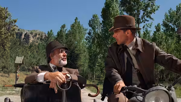 Henry Jones (Sean Connery) in the sidecar while Indiana Jones (Harrison Ford) drives a motorcycle