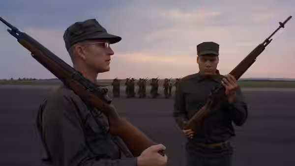 Two armed soldiers face each other on a runway with troops lined up at dusk