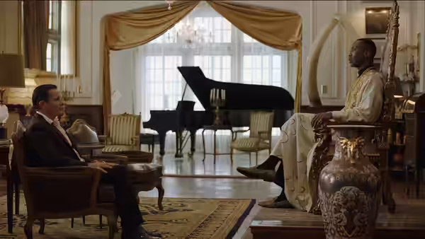 Tony Lip (Viggo Mortensen) and Dr. Don Shirley (Mahershala Ali) seated in a grand room with a piano