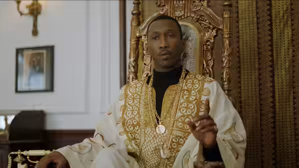 Dr. Don Shirley (Mahershala Ali) seated on an ornate throne in white and gold attire