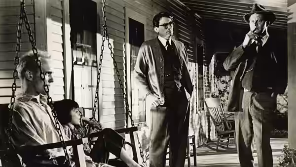 Atticus Finch (Gregory Peck) on a porch with children and a man