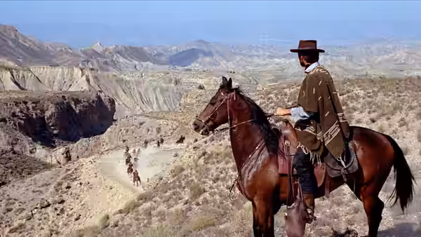 Manco (Clint Eastwood) on horseback overlooking distant riders